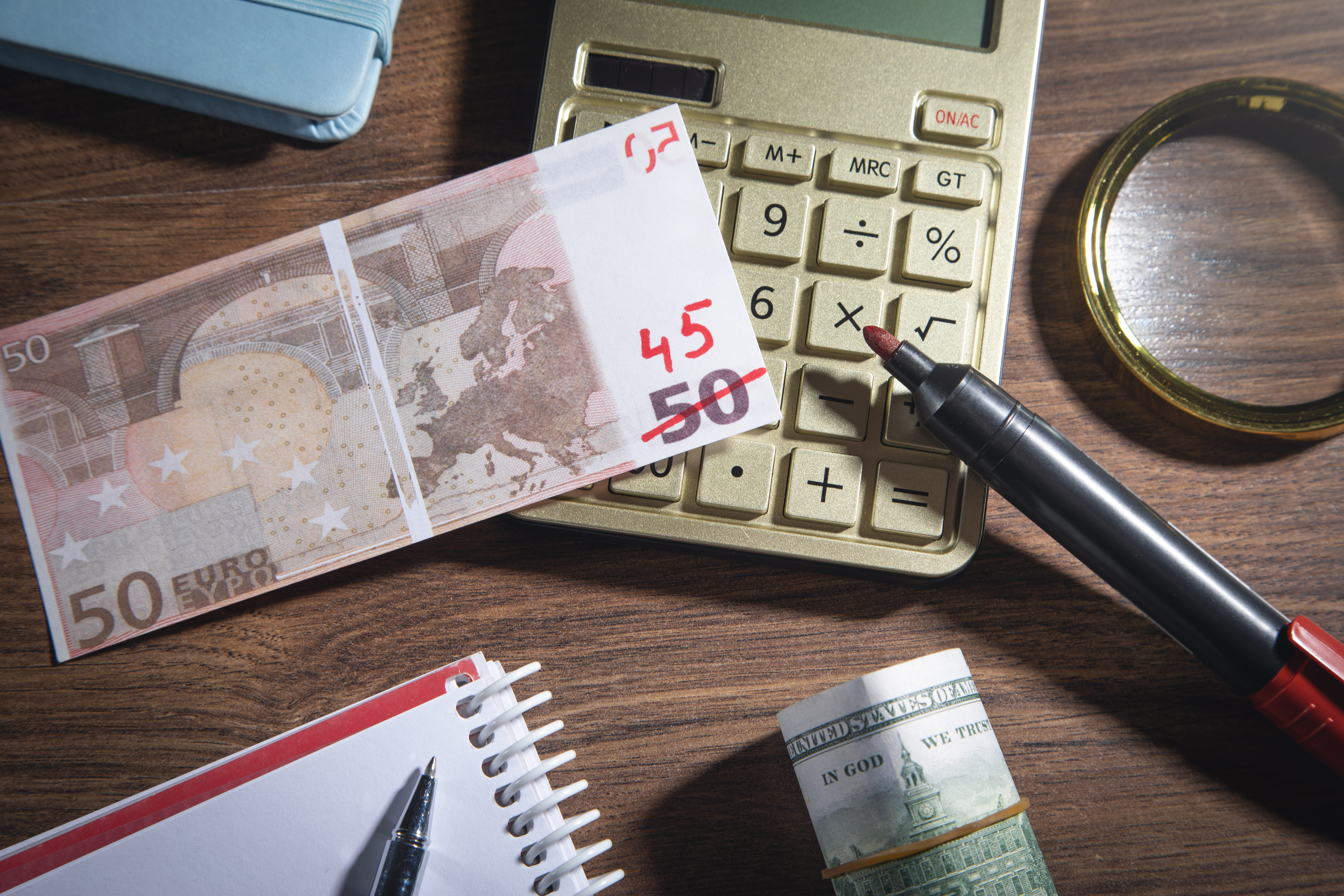 Euro money with a marker, calculator on the wooden background. I